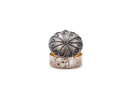 Caixa de comprimidos em prata com padrão relevado na tampa e interior dourado